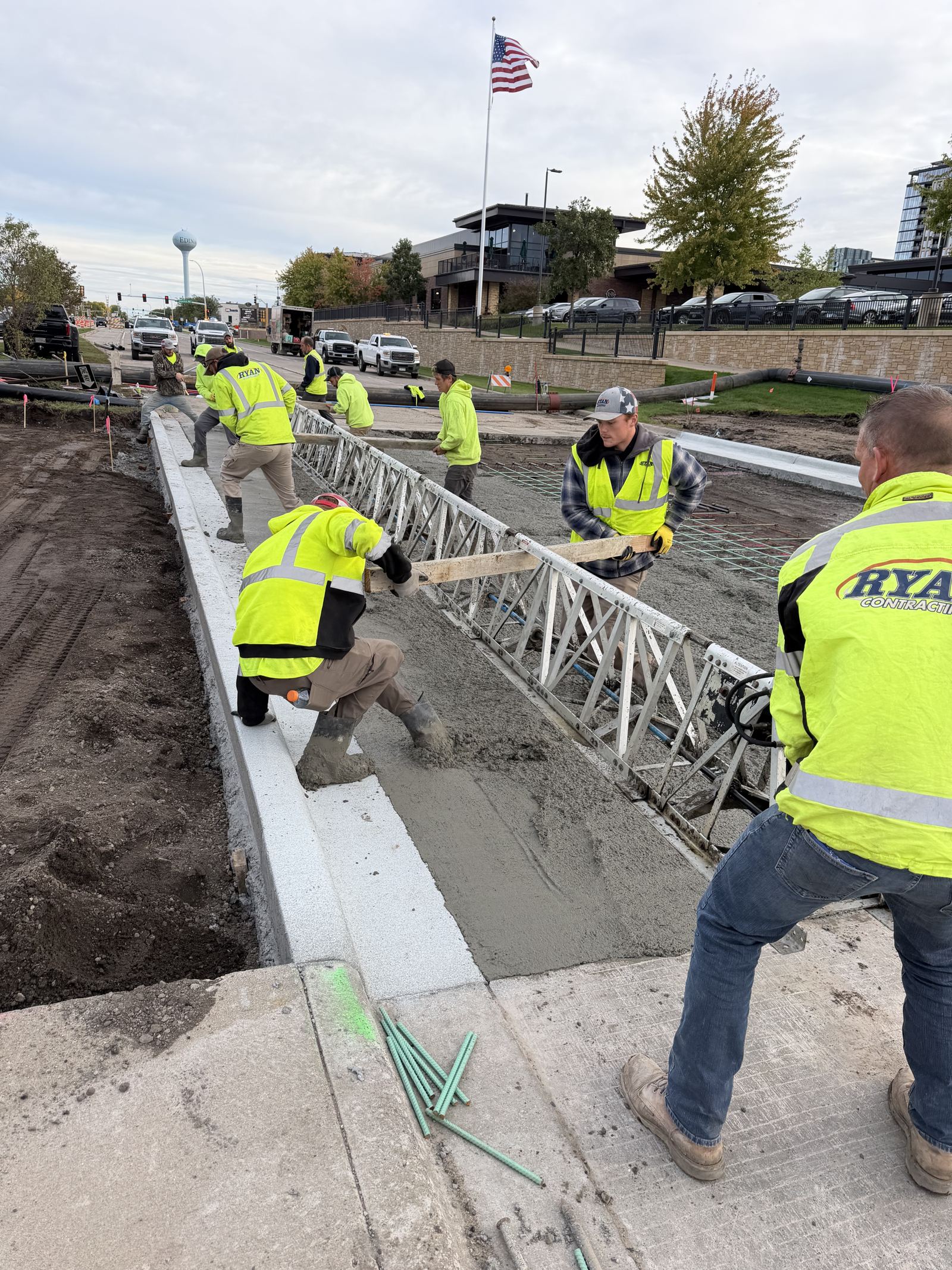 Ryan Contracting crew member in a company jacket working a concrete pour with the crew